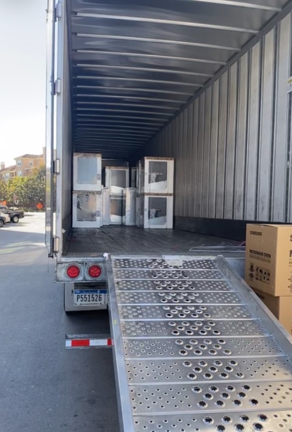 Appliances staged at a liftgate during prior multifamily project work