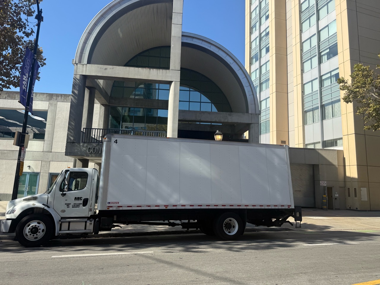 Full side profile of ABC DELIVERED's white 26-ft box truck in commercial service